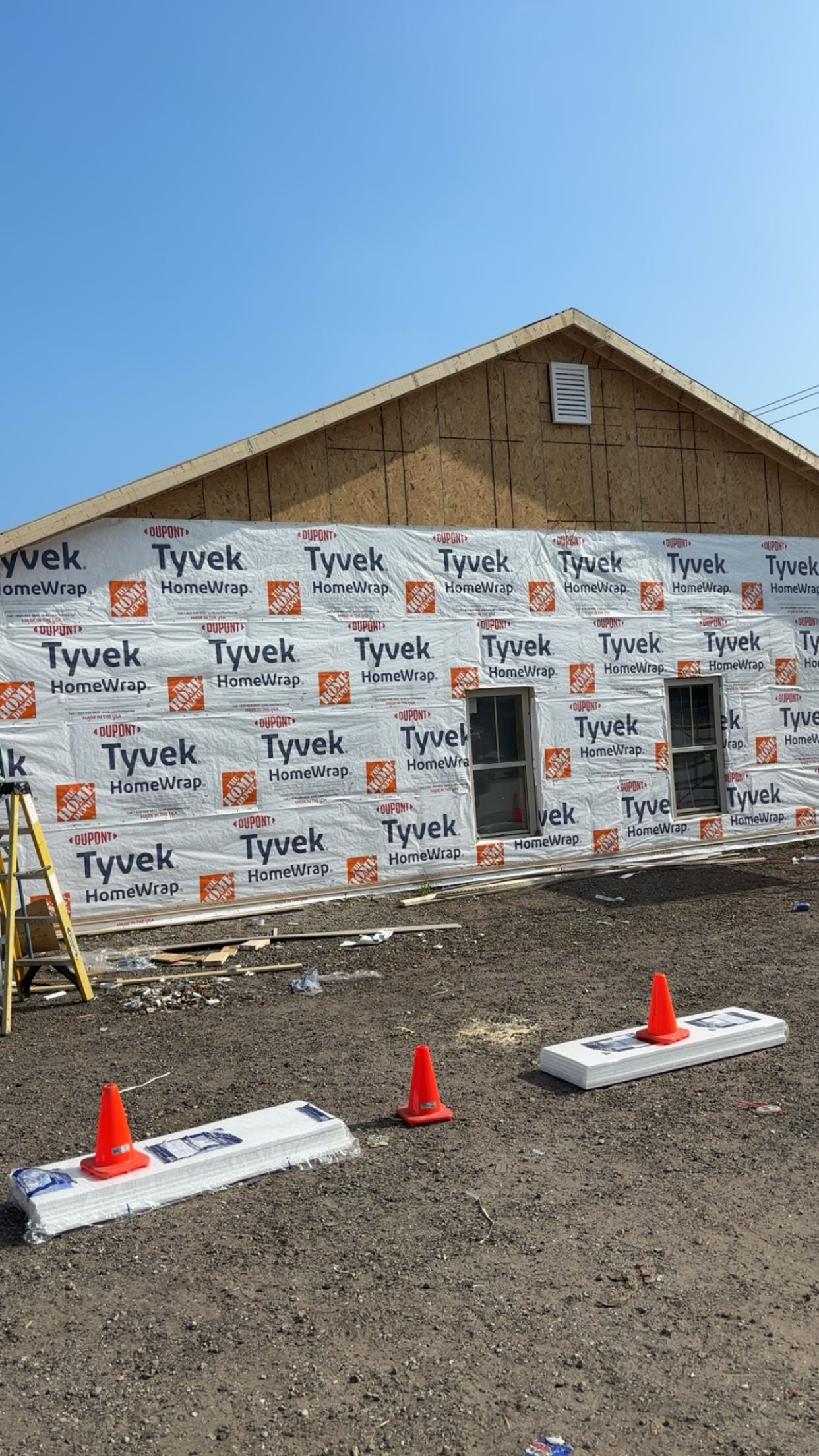 New home build in progress with house wrap before siding in Maine